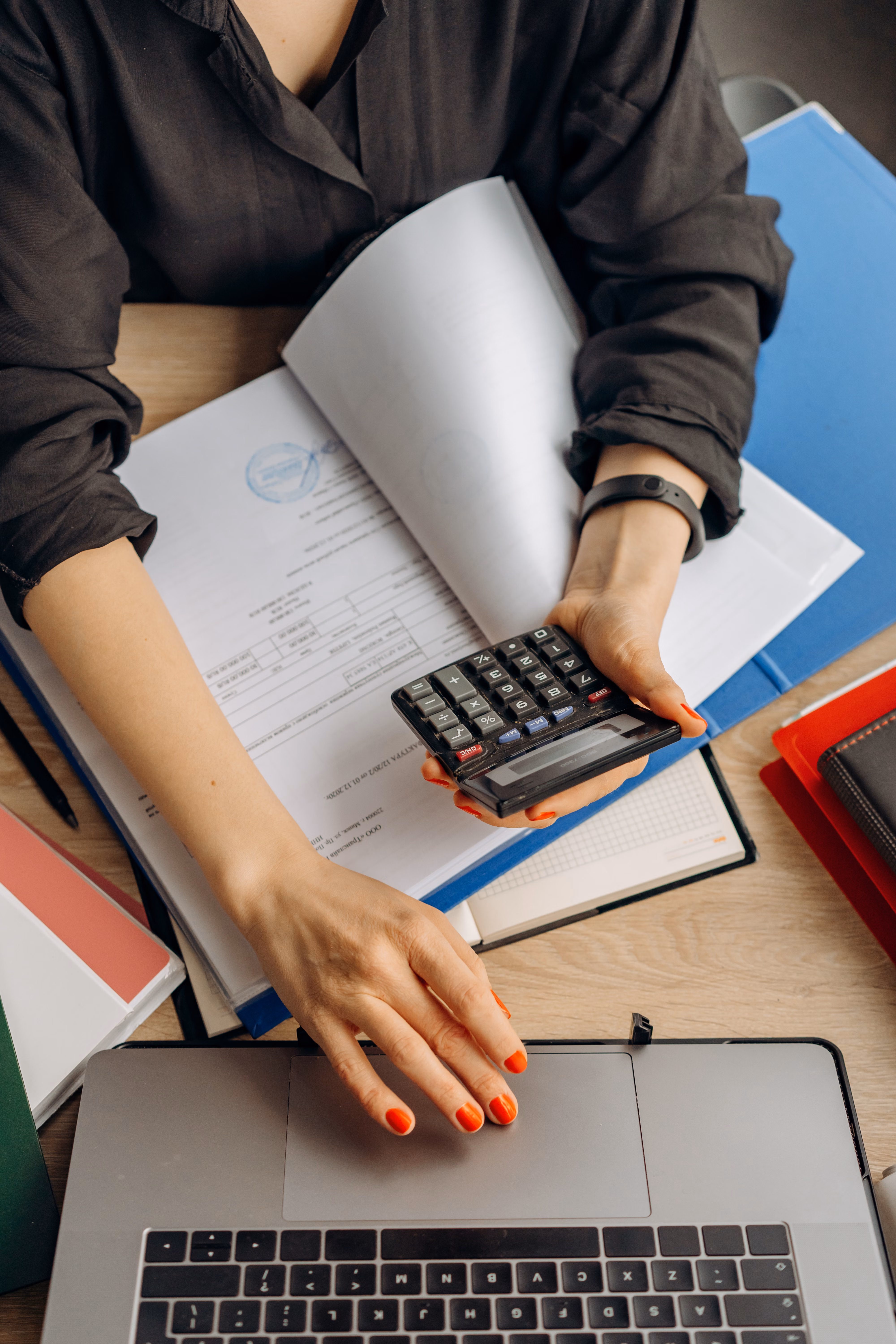Financial documents, calculator and laptop used for accounting work